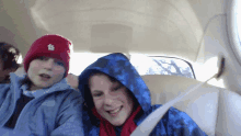 a boy wearing a red hat and a boy wearing a blue jacket