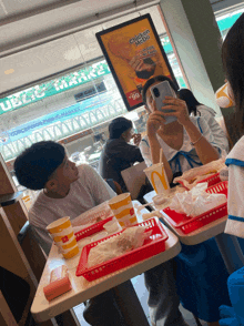 people sitting at a table in a mcdonald 's restaurant with a sign that says chicken mayo