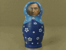 a green doll has a man 's face in the hole