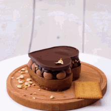 a heart shaped chocolate dessert with a biscuit on the side