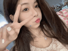 a girl with long hair is making a peace sign with her fingers