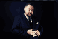 a man in a suit and tie is holding a cigarette in his hand
