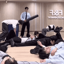 a group of young men are laying on the floor in front of a sign that says ' kn1 ' on it