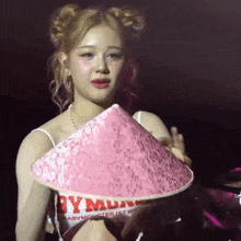 a woman holding a pink hat that says babymonster 1st