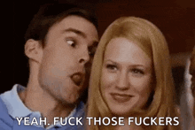 a man and a woman are standing next to each other and the woman is making a funny face .