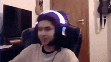 a man wearing headphones is sitting in a chair in front of a computer .