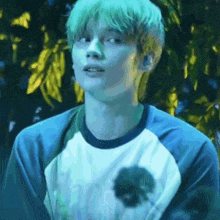 a close up of a person with green hair wearing a blue shirt .