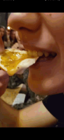 a close up of a person 's mouth eating a slice of pizza