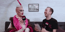 a man laughs while holding a microphone that says buzz
