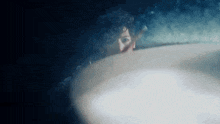 a close up of a person 's face in a dark room with a light shining on it .