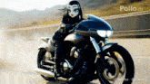 a woman is riding a motorcycle with a pollo ai logo behind her