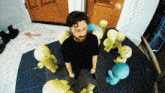 a man in a black shirt is surrounded by stuffed animals and a mat that says tnt on it