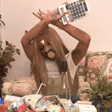a woman is holding a calculator over her head and wearing a shirt that says mick the dis