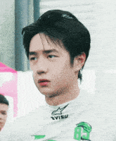a young man wearing a white evisu shirt