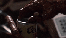 a close up of a person holding a can of soda