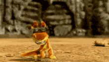 a toy lizard is standing on a dirt field in front of a rock wall .