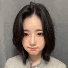 a young woman with short black hair is making a funny face and looking at the camera .