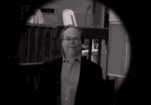 a black and white photo of a man in a suit walking down stairs .