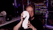 a man is holding a white number 2 in front of a purple background with a hat that has the letter b on it