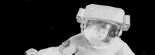 a black and white photo of a child in a space suit .