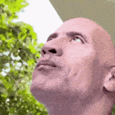a close up of a bald man looking up at the sky