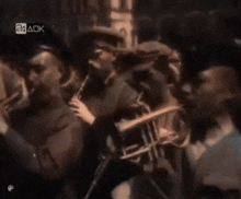 a group of men are playing trumpets in front of a sign that says 24 aok