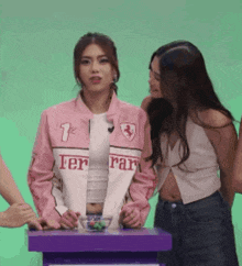 a woman wearing a pink jacket that says ferrari