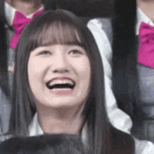 a woman is laughing with her mouth open in front of a group of girls .