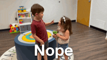 a boy and a girl are standing next to each other and the word nope is on the floor