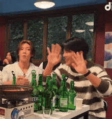 a group of people are sitting around a table with bottles of teri beer