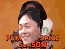 a man is holding a starbucks cup with the words pumpkin spice season written on it