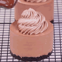 a chocolate cake with whipped cream on top is sitting on a wire rack