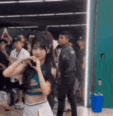 a cheerleader is making a heart shape with her hands while standing in front of a crowd .