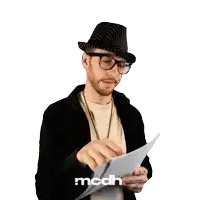a man wearing a hat and glasses is holding a piece of paper with mcdh written on the bottom
