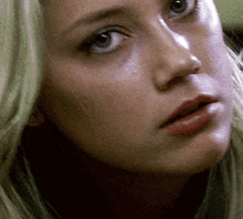 a close up of a woman 's face with a very serious look on her face .