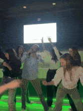 a group of people are dancing in front of a sign that says ' a ' on it