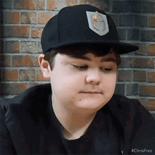 a young boy wearing a black hat with the word chris on it