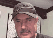a man with a mustache is wearing a hat and crying .