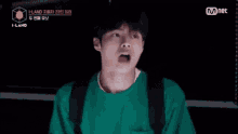 a man in a green sweater is making a funny face .