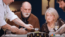 a group of people sitting at a table with nbc written on the bottom