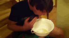 a man is sitting on a staircase drinking from a bowl .