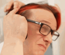 a man with red hair is wearing glasses