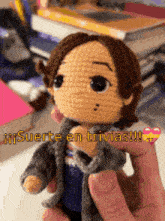 a person is holding a crocheted doll that says " suerte en trivias " on it