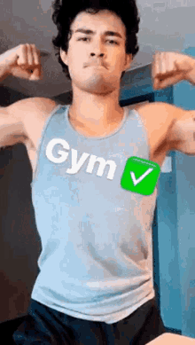 a man in a tank top with the word gym on it is flexing his muscles in a gym .