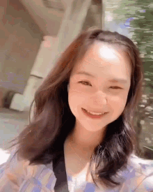 a young woman with long brown hair is smiling for the camera .