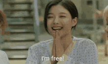 a woman in a hospital gown is smiling and says i 'm free