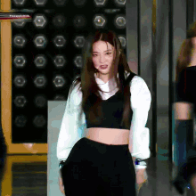 a woman in a black crop top and black skirt
