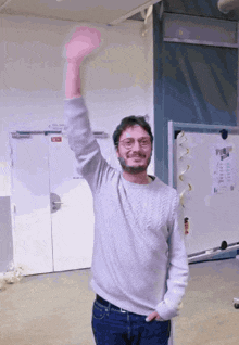 a man raising his arm in front of a door that says colonne