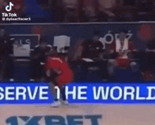 a basketball game is being played in front of a sign that says ' we serve the wo '
