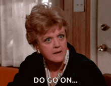 a woman with a serious look on her face says " do go on "
